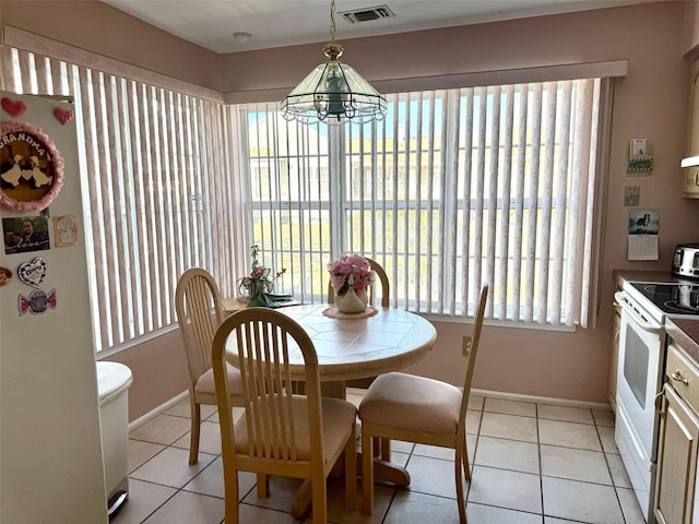 dining room featuring light tile patterned flooring, baseboards, and a wealth of natural light