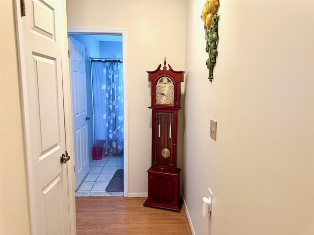 corridor with baseboards and light wood-type flooring
