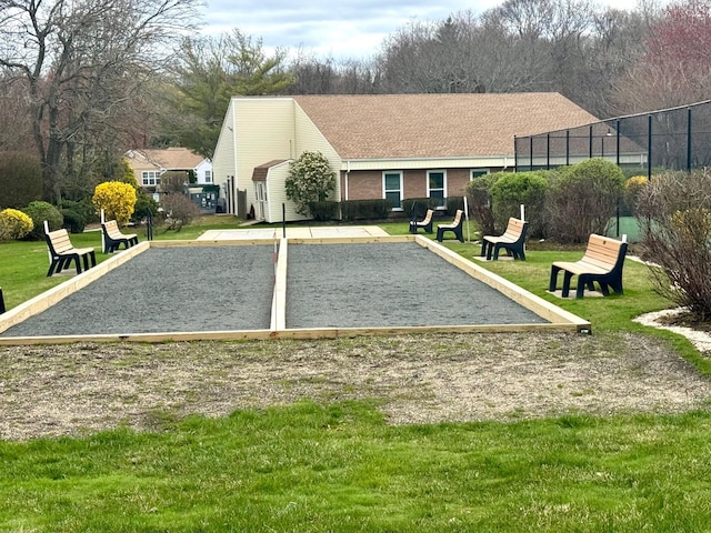 view of property's community featuring uncovered parking, fence, and a lawn