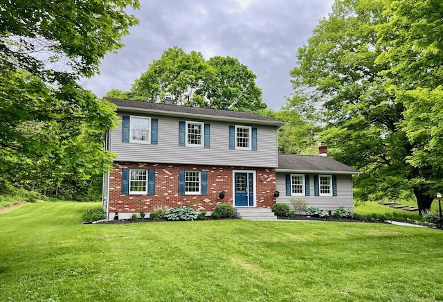 452 Hibernia Rd, Salt Point, NY 12578 - colonial inspired home with a chimney, a front yard, brick siding, and view of wooded area