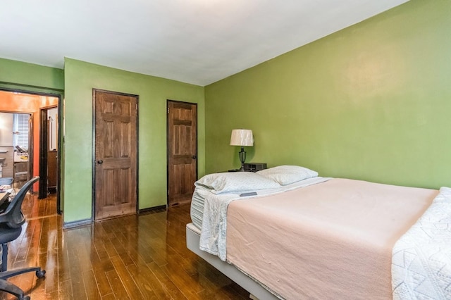 bedroom with wood finished floors and baseboards