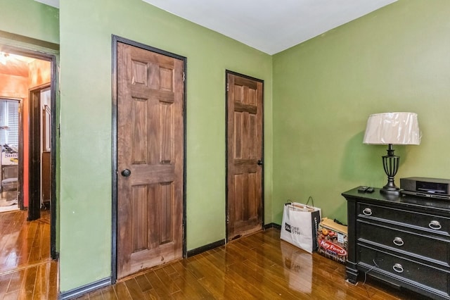 bedroom with baseboards and dark wood-style flooring