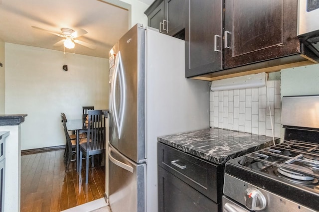 kitchen featuring hardwood / wood-style floors, a ceiling fan, baseboards, decorative backsplash, and appliances with stainless steel finishes
