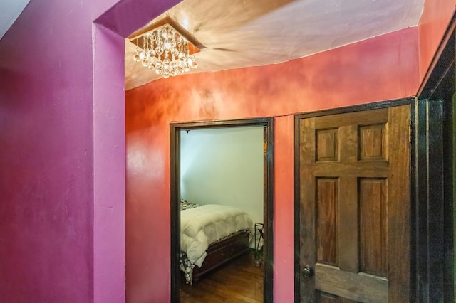 bedroom featuring wood finished floors and an inviting chandelier
