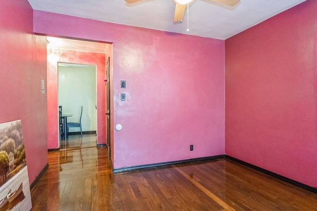 unfurnished room with wood finished floors, ceiling fan, and baseboards