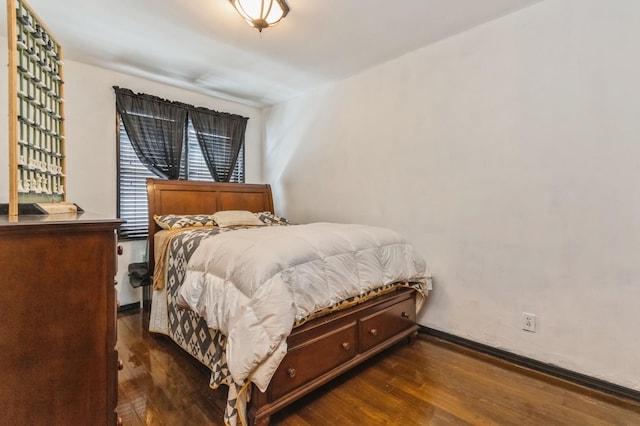 bedroom featuring dark wood-style floors and baseboards