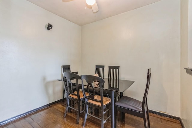 dining space with a ceiling fan, hardwood / wood-style floors, and baseboards