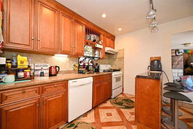 102-25 163rd Dr, Howard Beach, NY 11414 - kitchen featuring light tile patterned floors, white appliances, brown cabinetry, under cabinet range hood, and backsplash
