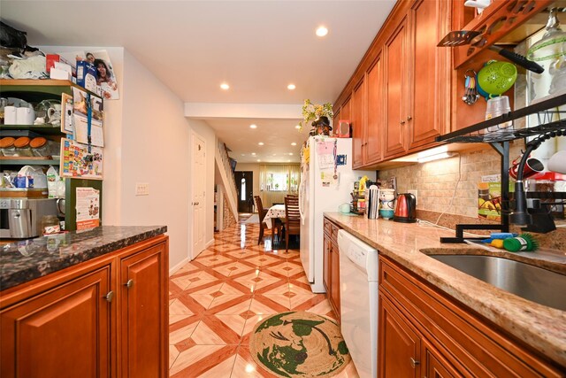 102-25 163rd Dr, Howard Beach, NY 11414 - kitchen with recessed lighting, white appliances, brown cabinetry, dark stone counters, and decorative backsplash