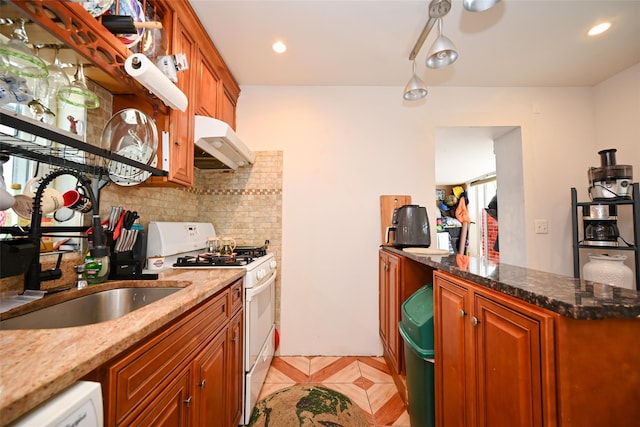 102-25 163rd Dr, Howard Beach, NY 11414 - kitchen featuring tasteful backsplash, dishwasher, under cabinet range hood, white range with gas stovetop, and dark stone counters