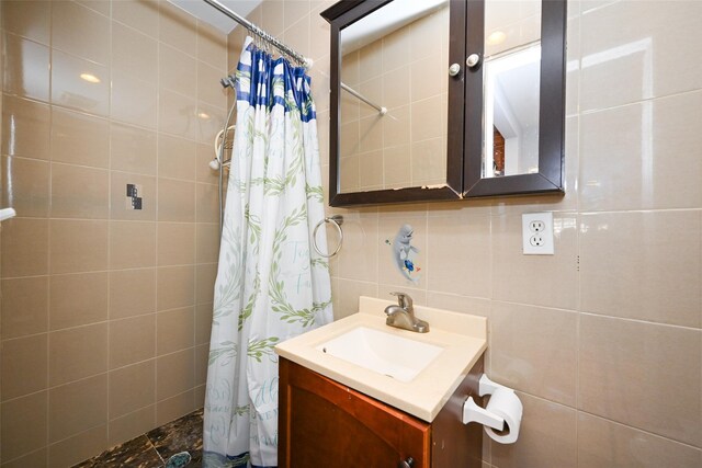 102-25 163rd Dr, Howard Beach, NY 11414 - bathroom featuring tiled shower, vanity, tile walls, and decorative backsplash