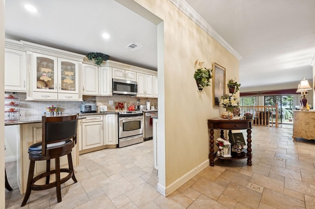 60 Southgate Cir, Massapequa Park, NY 11762 - kitchen with stainless steel appliances, stone tile flooring, crown molding, baseboards, and decorative backsplash