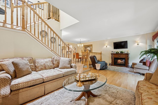 60 Southgate Cir, Massapequa Park, NY 11762 - living area with a chandelier, a glass covered fireplace, wood finished floors, and stairs