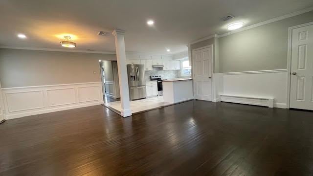 unfurnished living room featuring ornamental molding, dark wood-style floors, recessed lighting, a wainscoted wall, and a baseboard radiator