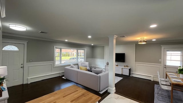 living area featuring ornamental molding, decorative columns, a wainscoted wall, a baseboard heating unit, and a baseboard radiator