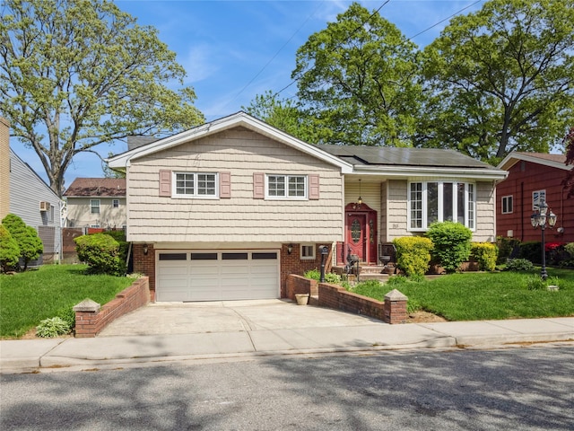915 Derrick Adkins Ln, West Hempstead, NY 11552 - bi-level home featuring roof mounted solar panels, a garage, concrete driveway, and a front lawn