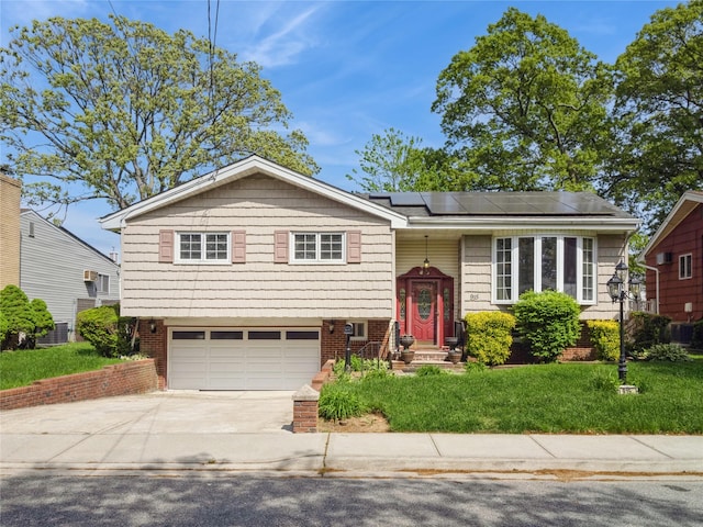 915 Derrick Adkins Ln, West Hempstead, NY 11552 - bi-level home featuring roof mounted solar panels, driveway, an attached garage, and a front yard