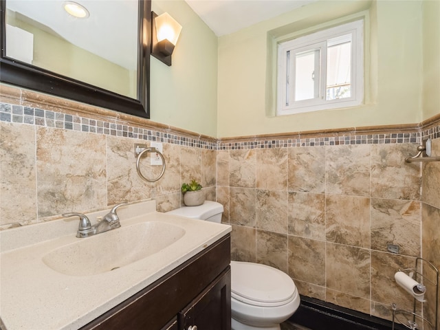 915 Derrick Adkins Ln, West Hempstead, NY 11552 - half bathroom featuring tile walls, toilet, vanity, and a wainscoted wall