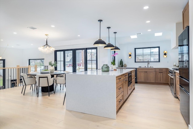 64 Jane Ct, Westbury, NY 11590 - kitchen with visible vents, a sink, light wood-style floors, stainless steel range with gas cooktop, and recessed lighting