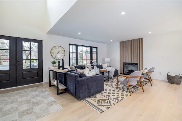 64 Jane Ct, Westbury, NY 11590 - living room featuring recessed lighting, light wood finished floors, french doors, and a large fireplace