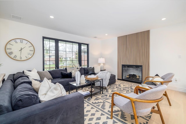 64 Jane Ct, Westbury, NY 11590 - living area with light wood-style flooring, a glass covered fireplace, visible vents, and recessed lighting