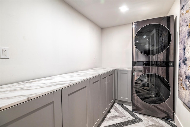 64 Jane Ct, Westbury, NY 11590 - laundry area with stacked washing maching and dryer, marble finish floor, and cabinet space