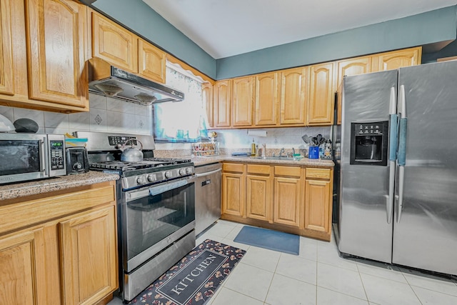 97 Arlington Ave, Valley Stream, NY 11580 - kitchen featuring a sink, under cabinet range hood, stainless steel appliances, backsplash, and light tile patterned flooring