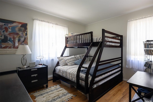 bedroom featuring baseboard heating and wood finished floors