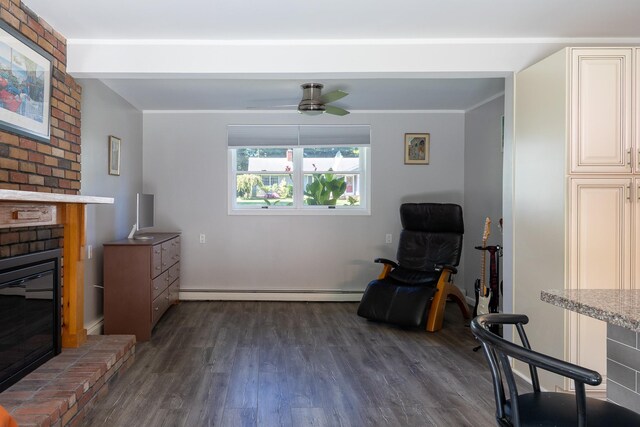 living area featuring ceiling fan, a baseboard radiator, a brick fireplace, and dark wood finished floors