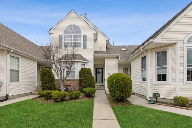 view of front of property with a front lawn and roof with shingles