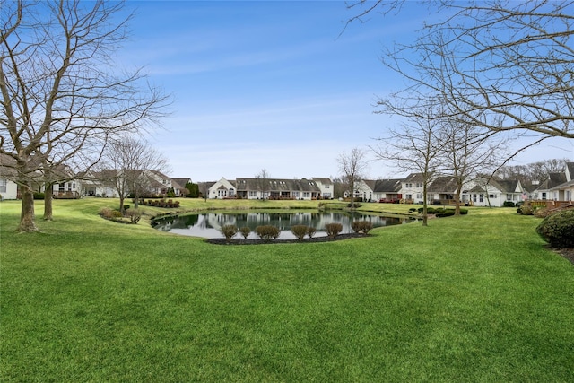 view of community featuring a yard, a residential view, and a water view