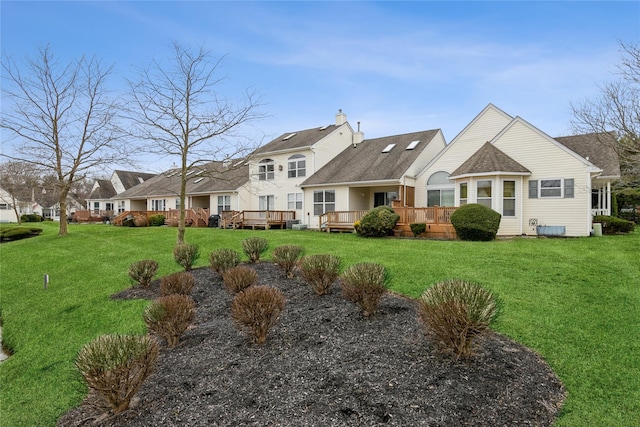 back of house featuring a lawn and a deck