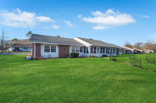view of front of property featuring brick siding and a front lawn
