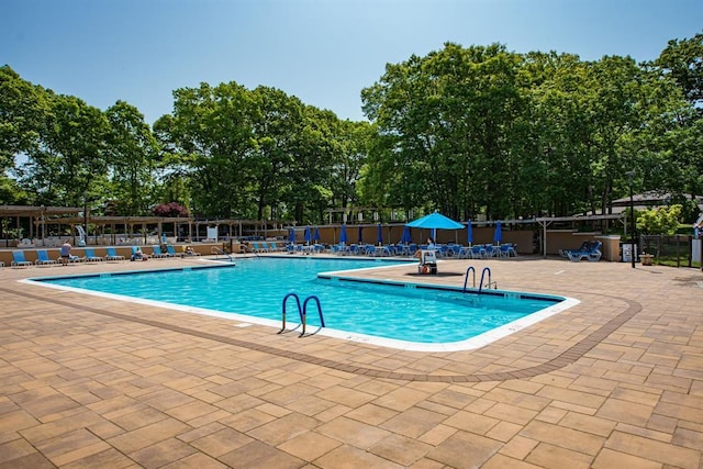 community pool with fence and a patio