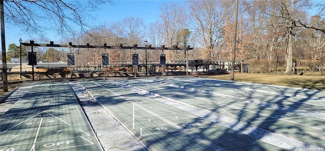 view of community with fence and shuffleboard