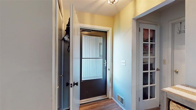 doorway featuring baseboards, dark wood-style flooring, and visible vents
