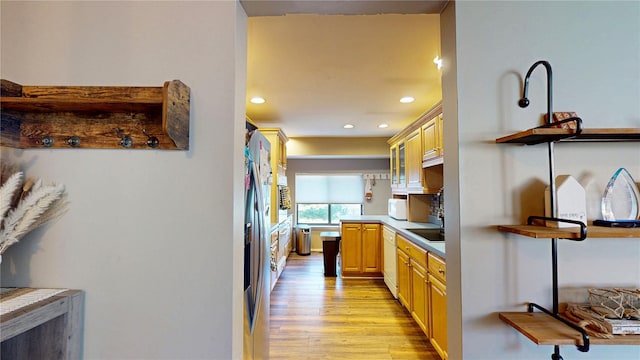 kitchen with recessed lighting, light brown cabinets, light wood-type flooring, and dishwasher