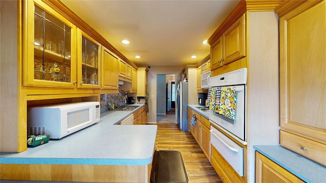 kitchen with wood finished floors, white appliances, recessed lighting, a sink, and a warming drawer