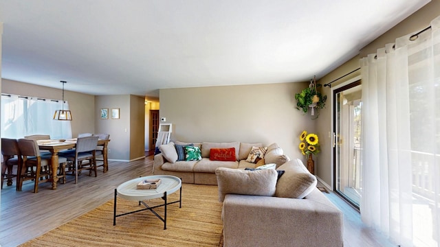 living area with baseboards and wood finished floors