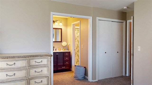 bedroom featuring a closet, connected bathroom, and light carpet