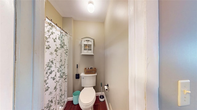 full bath featuring baseboards, curtained shower, toilet, and wood finished floors