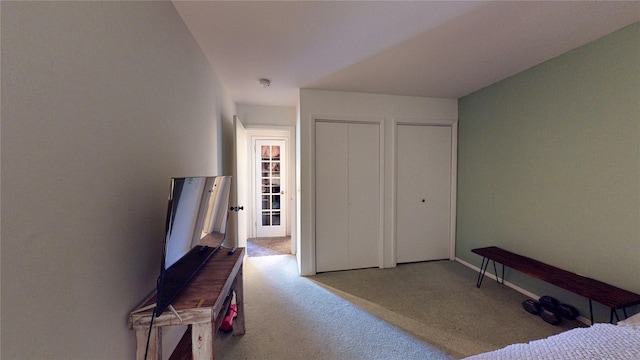 carpeted bedroom with baseboards and multiple closets