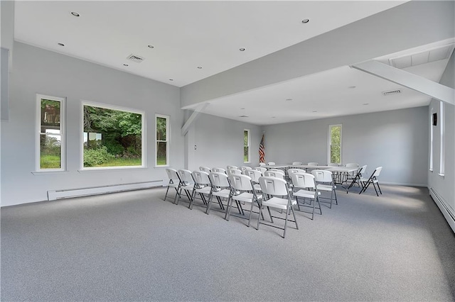 carpeted dining area with visible vents, plenty of natural light, and a baseboard heating unit
