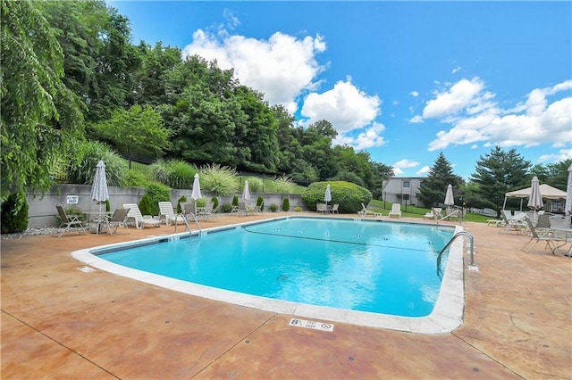 pool featuring fence and a patio