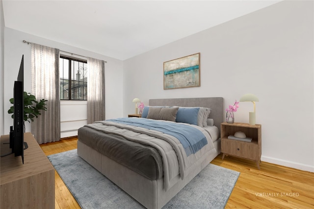 41-23 76th St # 2B, Elmhurst, NY 11373 - bedroom featuring light wood-style floors and a baseboard heating unit