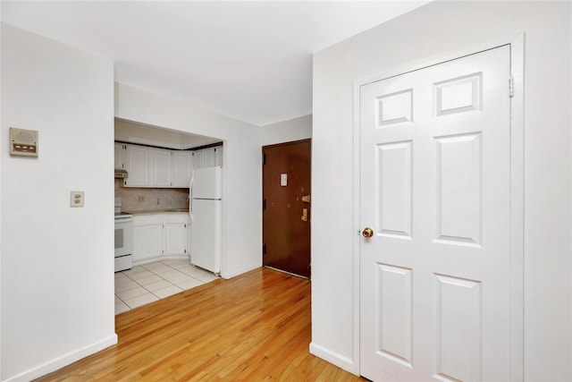 41-23 76th St # 2B, Elmhurst, NY 11373 - kitchen featuring white appliances, white cabinetry, light wood-style floors, light countertops, and backsplash