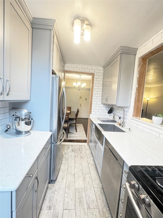 1475 Thieriot Ave Unit 6E, Bronx, NY 10460 - kitchen featuring appliances with stainless steel finishes, gray cabinetry, a chandelier, and tasteful backsplash