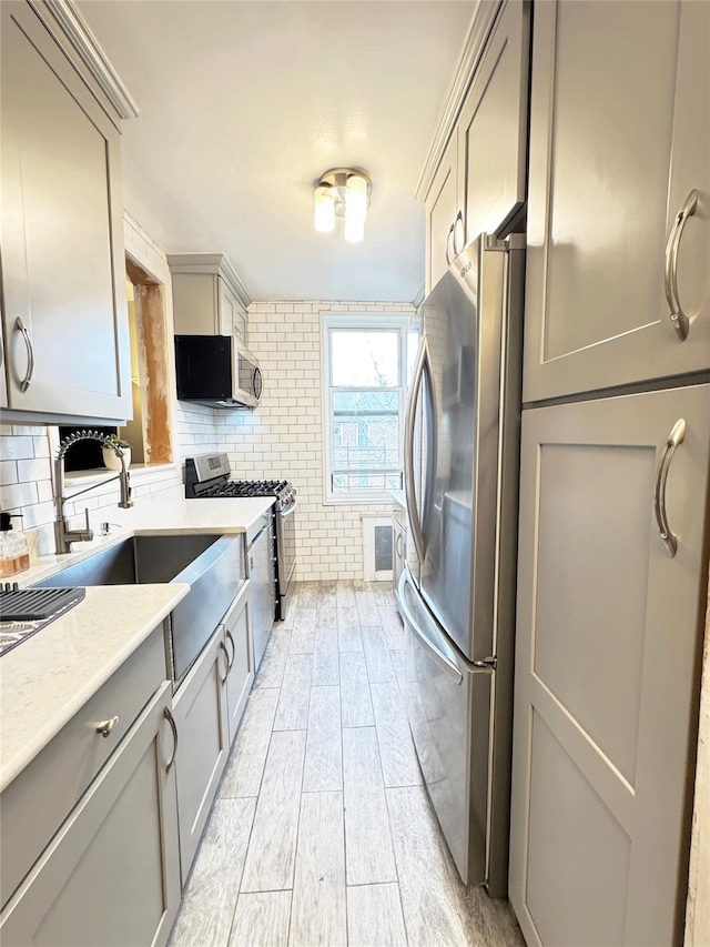 1475 Thieriot Ave Unit 6E, Bronx, NY 10460 - kitchen featuring appliances with stainless steel finishes, gray cabinets, light wood-style flooring, and a sink