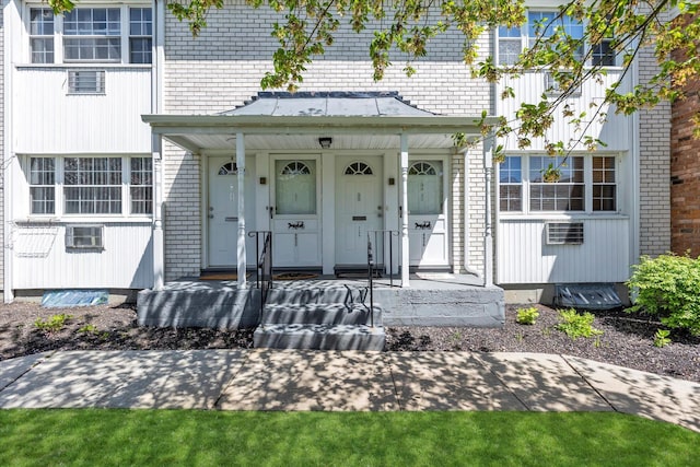 4410 Wilshire Ln Unit 4410, Oakdale, NY 11769 - doorway to property featuring brick siding and a porch