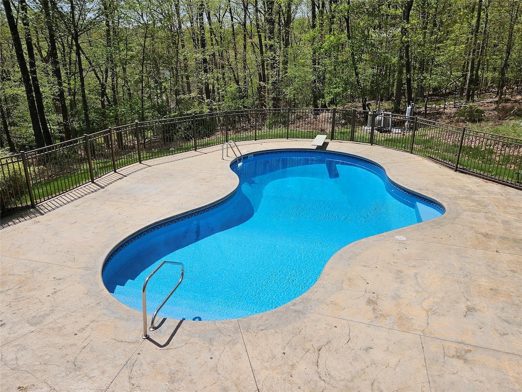 view of swimming pool featuring a patio and fence
